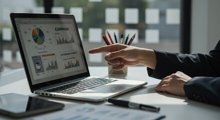 Business Analysis: Hand Pointing at Campaign Data on Laptop Screen