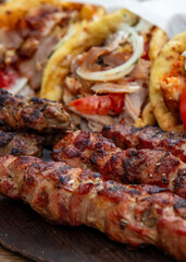 Gyro sliced meat pita bread wraps, pork souvlaki skewers, traditional street food, closeup