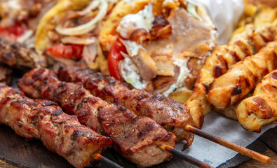 Gyro sliced meat pita bread wraps, meat souvlaki skewers, traditional street food, closeup
