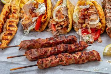 Gyro sliced meat pita bread wraps, pork souvlaki skewers, traditional street food, closeup