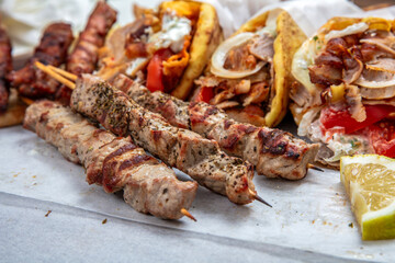 Gyro sliced meat pita bread wraps, pork souvlaki skewers, traditional street food, closeup