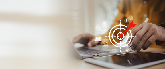 Digital Business Strategy Target Achievement with Data Analysis and Marketing Goal Setting, Man holding  target with arrow hitting this symbolizes achieving core business goals, digital strategy