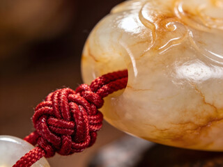 traditional chinese jade amulet jewelry with intricate carving and braided string