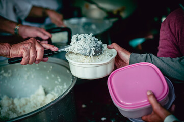 The hands of the hungry are asking for food from the donor