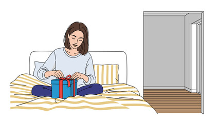 Woman tying ribbon on a gift box while sitting on the bed