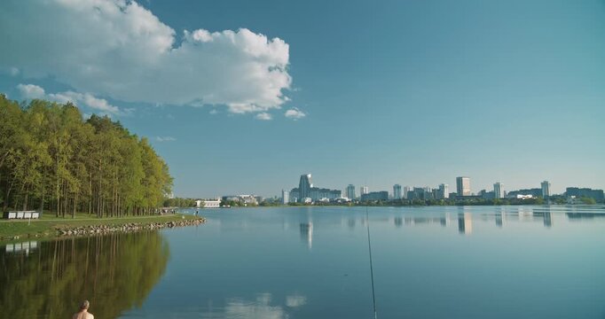 Minsk, Belarus. Reservoir Drozdy. Time Lapse View On Forest, Public Park And City On Background. People Resting Walking At Riverside In Summer Day. City Pond And Park.