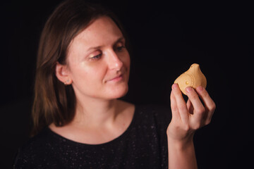 Woman holding a traditional handmade ceramic bird ocarina. Cultural heritage and traditional craft concept. Musical instrument art.