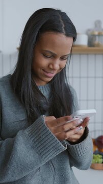 Internet addiction and social media overuse, young black woman with smartphone. Female user with mobile phone in hands, modern technology for communication, testing new mobile app, chatting online