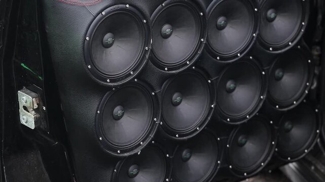 Bobruisk, Belarus 4.11.25: Close up view of car door. Custom audio system with multiple black speakers, subwoofers, and tweeters. Integrated into black leather, red stitching