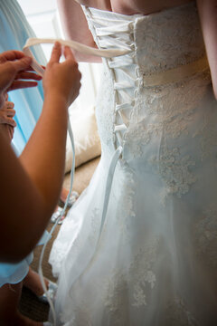 Bride Getting Laced into Wedding Dress