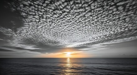 Dramatic Sunset Over Calm Ocean with Textured Clouds.