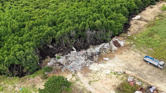 Aerial view shows scattered waste and construction debris beside a mangrove forest clearing in Busuanga Palawan with a truck parked near the site