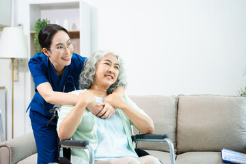 Obraz premium Asian caregiver doctor examine older patient woman therapist nurse at nursing home taking care of senior elderly woman sit on sofa.Medical service concept.