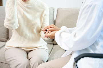 Fototapeta premium Asian female hands touching senior male hand Helping hands take care of the elderly concept in hospital