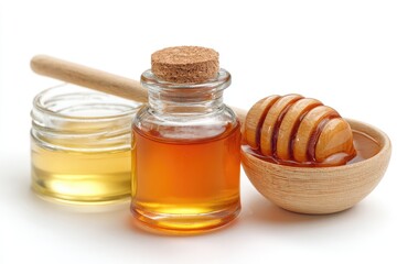 Honey in jars and dipper; viscous, amber liquid against white background