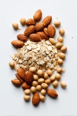 Almonds, soybeans, and oat flakes form a pile on a bright white surface