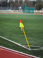 Soccer corner flag on an empty sports field with green turf. © SashaMagic