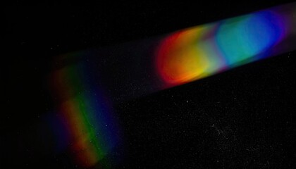 Refracted light creates a colorful spectrum against a dark background