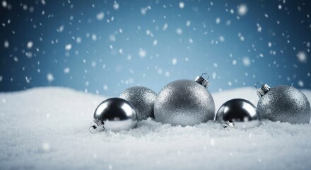 Silver Christmas ornaments on snowy backdrop