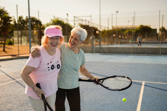 Senior women friends enjoying tennis on court