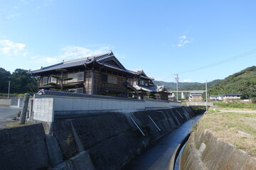 Fototapeta premium Traditional Japanese wooden houses beside a rural canal along the Shikoku Henro pilgrimage in Japan