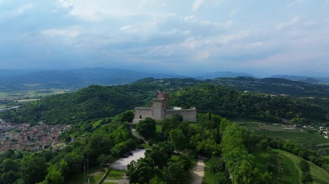 top of the hill aerial showcasing Castello di Romeo and the valley below Montecchio Maggiore, majestic view of lush green Italian town and agriculture in a fertile farming region