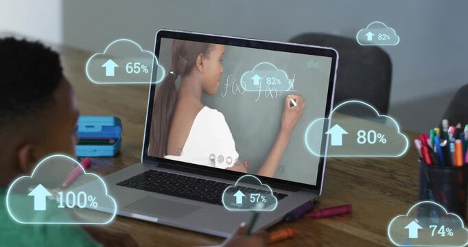 Animation of clouds with uploading over african american boy having online lessons on laptop