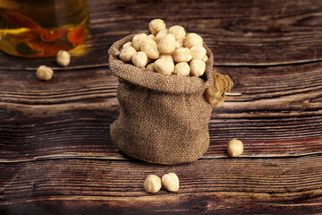 Raw Chickpeas in Burlap Sack on Wooden Table