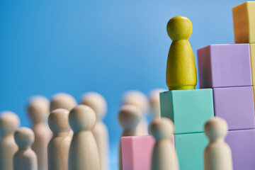 Wooden figurine climbing up the success steps.