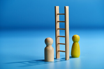 toy ladder and  figurine against blue background with shadow.