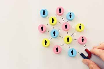 Concept image of a magnet attracting a group of people. metaphor of media influence and human resources