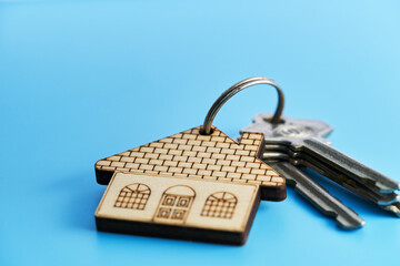 wood house shape keyring against blue background