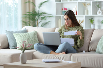 Perplexed woman doing online accounting with laptop
