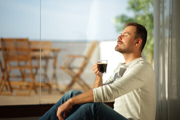 Man holding coffee cup breathing fresh air
