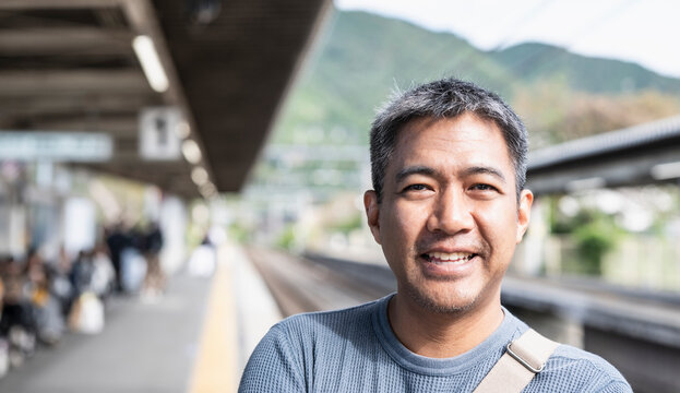 Man waiting on the platform of a train station in Japan