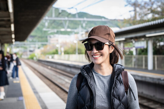 Woman waiting on the platform of a train station in Japan