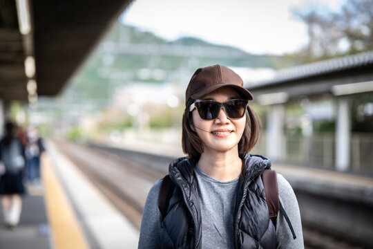 Woman waiting on the platform of a train station in Japan
