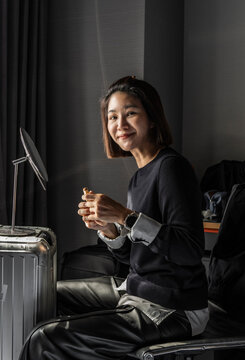 Woman using her suitcase as a makeshift make up table