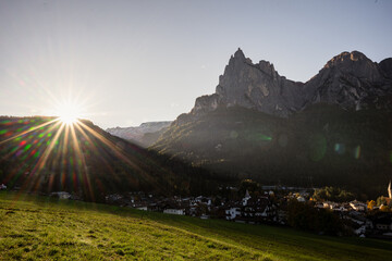 Sunrise over alpine village and dramatic Dolomites mountain landscape