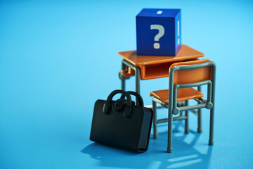 Small toy school desk and chair with cube with question mark