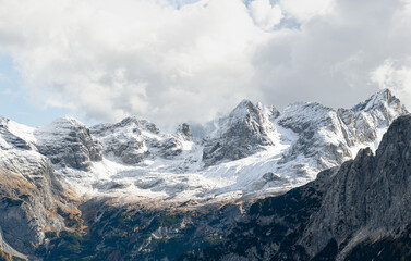 Snow covered Dolomites mountain peaks under dramatic clouds