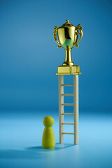 wood figurine and gold trophy on top of step ladder