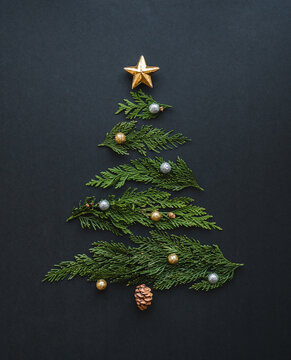 Top view of Christmas tree made of cedar boughs on black background.