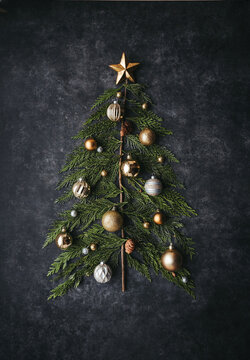Top view of Christmas tree made of cedar boughs on black background.