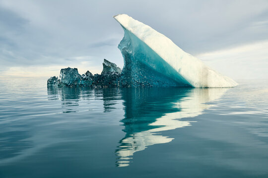 Reflecting Iceberg in Glacial Lagoon in Dramatic Light