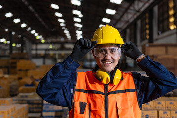Confident engineer man with safety helmet standing analyzing with tablet in factory warehouse. Asian technician factory inspection and control machinery in industry factory.