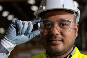 Close up asian man technician engineer wearing and adjust protective safety glasses. Safety...