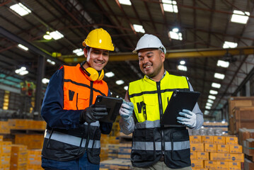 Professional asian engineer and technician wearing safety helmet analyzing meeting with tablet in factory warehouse. Confident factory workers group inspection industry factory. Teamwork concept.