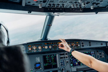 Pilot adjusting altitude controls in aircraft cockpit during flight