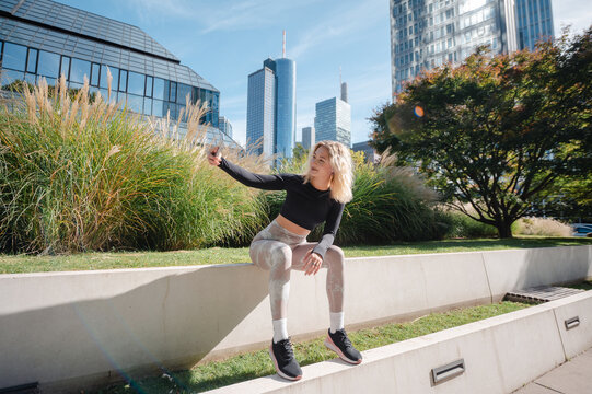 Girl taking a selfie with a smartphone in a modern city park